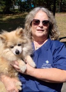 Woman wearing sunglasses holding a dog